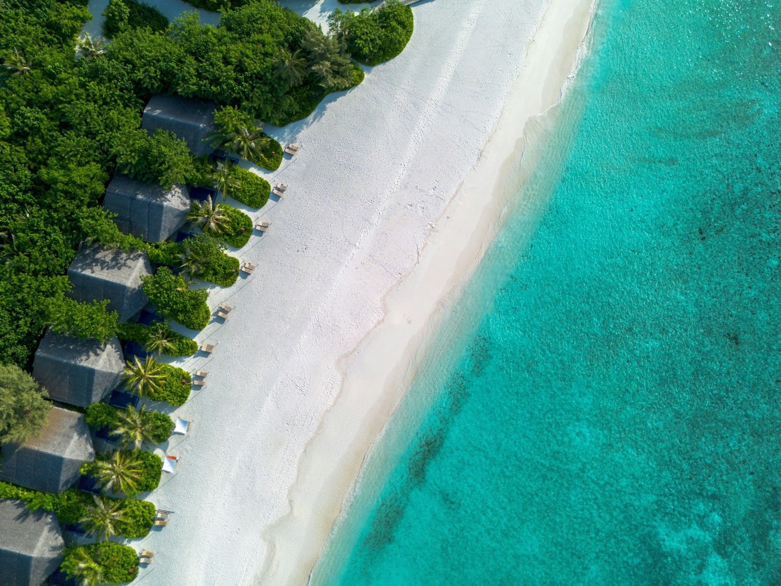 Aerial of overwater villas and turquoise water in the Indian Ocean