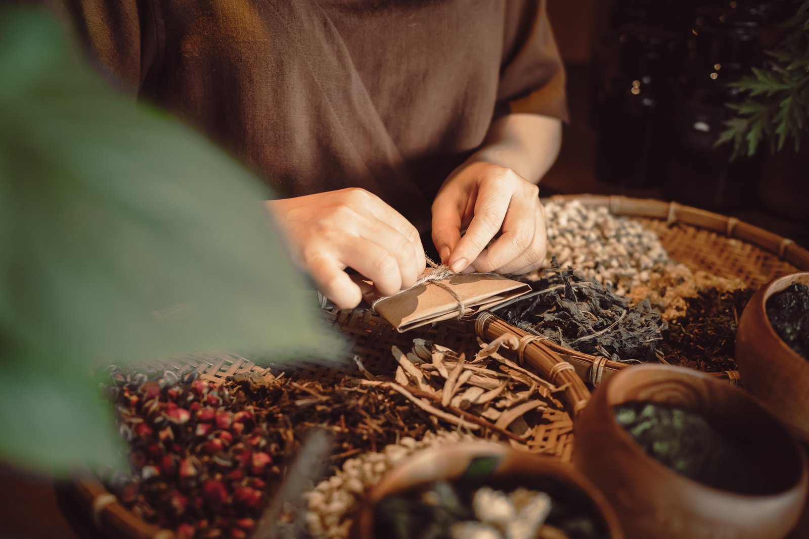 Hands placing dried herbs into a small ceramic bowl