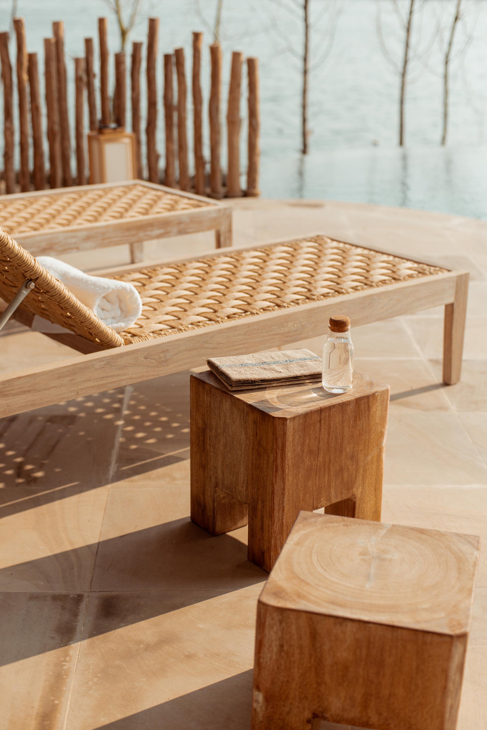 Rattan lounger by a calm river — space and quiet for families